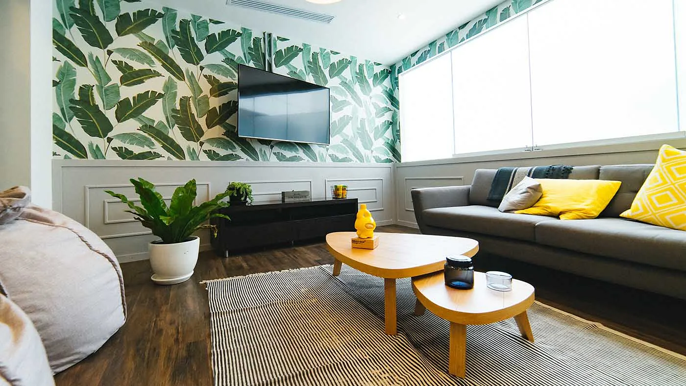 Living room with a botanical feature wallpaper and dark sofa